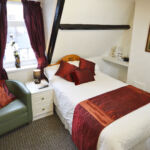 Double room with own private shower (but not en-suite), overlooking the free parking bays to the west of the Guest House. Single supplement available on this room.